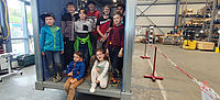 Gruppe von Kindern sitzt in einem großen Metallcontainer.