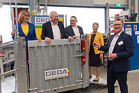 Fünf Personen stehen um eine GEDA-Maschine herum.