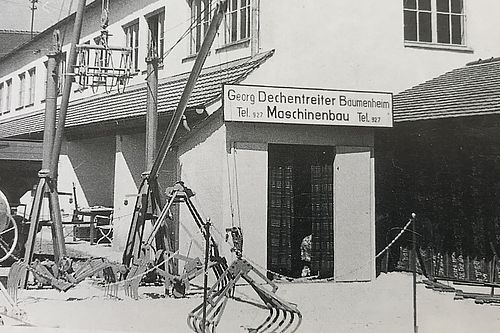Ein altes Foto von einem Gebäude mit einem Schild "Georg Dechentreiter Baumenheim, Maschinenbau.