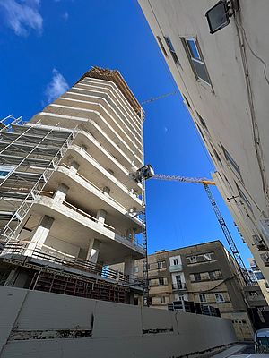 Ein unvollendetes Hochhaus wird von einem Baukran umgeben.