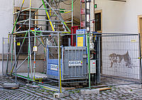 Ein Bauaufzug ist von einem Bauzaun eingezäunt.